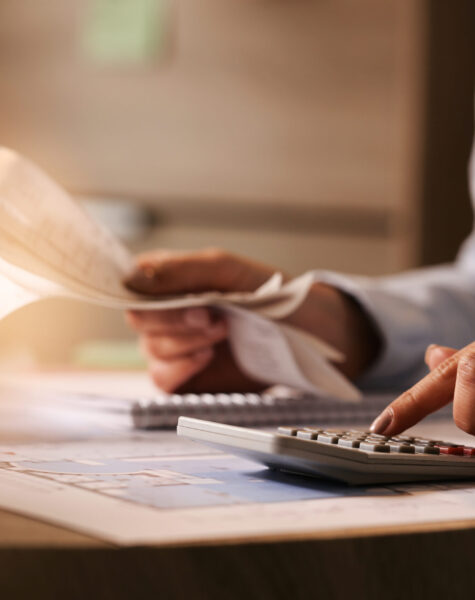 Close-up of business accountant using calculator while working i Close-up of economist using calculator while going through bills and taxes in the office.