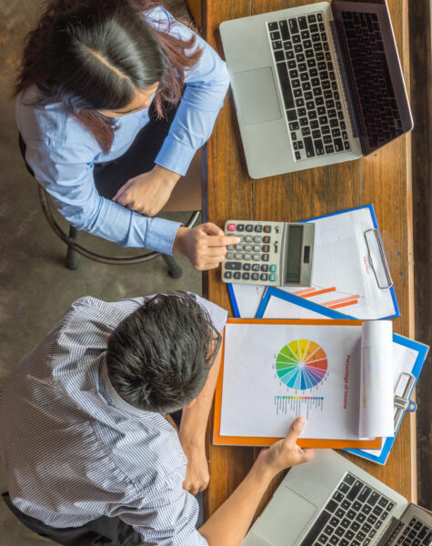 Young business employee discuss about financial number on document Aerial view of young business employee discuss about financial number on document